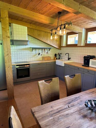 a kitchen with a wooden ceiling and a table with chairs at Sportpension Enzian in Saalbach Hinterglemm