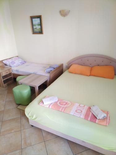 una habitación con dos camas y una mesa en Apartmani Pikula, en Sutomore