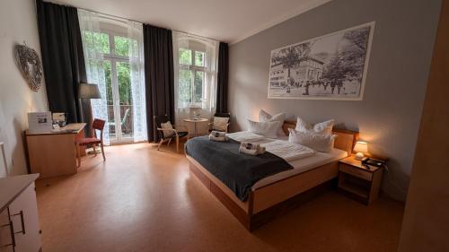 a bedroom with a bed in a room with windows at Villa Regina Bad Freienwalde in Bad Freienwalde