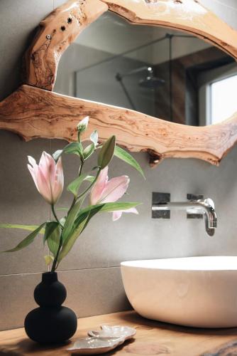 a bathroom with a sink and a vase with a flower at Villa Di Leon - Uniquely Designed Villa with Pool in a Picturesque Village near Famous Porto Limnionas, Offering Exceptional Hospitality By Villa Mana Gers in Agios Leon