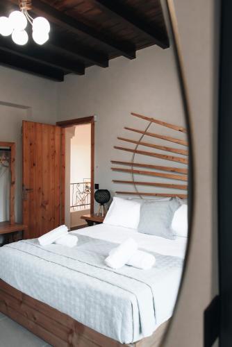 a bedroom with a large white bed with a wooden headboard at Villa Di Leon - Uniquely Designed Villa with Pool in a Picturesque Village near Famous Porto Limnionas, Offering Exceptional Hospitality By Villa Mana Gers in Agios Leon