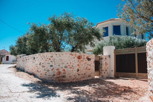 a retaining wall in front of a house at Villa Di Leon - Uniquely Designed Villa with Pool in a Picturesque Village near Famous Porto Limnionas, Offering Exceptional Hospitality By Villa Mana Gers in Agios Leon