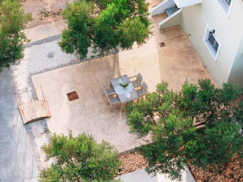 an overhead view of a patio with tables and trees at Villa Di Leon - Uniquely Designed Villa with Pool in a Picturesque Village near Famous Porto Limnionas, Offering Exceptional Hospitality By Villa Mana Gers in Agios Leon