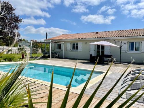 une maison avec une piscine devant une maison dans l'établissement LOMALI Maison familiale climatisée piscine, à Loupes