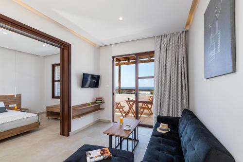 a living room with a couch and a bed and a window at Costa Lindia Blue Star - Adults Only in Lartos