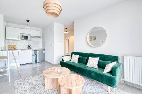 un salon avec un canapé vert et une table dans l'établissement Sweet Green - T2 avec balcon à Toulouse, à Castanet-Tolosan