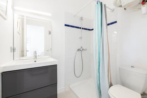 une salle de bain blanche avec un lavabo et une douche dans l'établissement Aurore - Studio 24, à Carcassonne