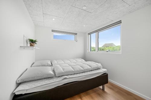 Exclusive Newly Built Pool House With Outdoor Spa - 1032 في رينكوبنج: سرير في غرفة بيضاء مع نافذة