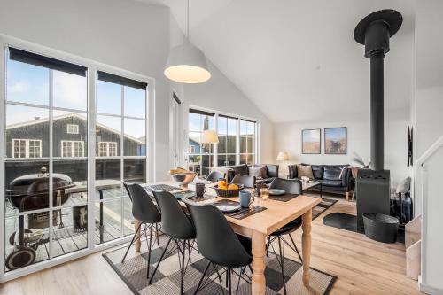 a dining room and living room with a table and chairs at Lovely Spa House - 1006 in Hvide Sande