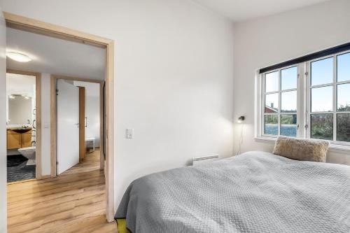a bedroom with a bed and a large window at Lovely Spa House - 1006 in Hvide Sande