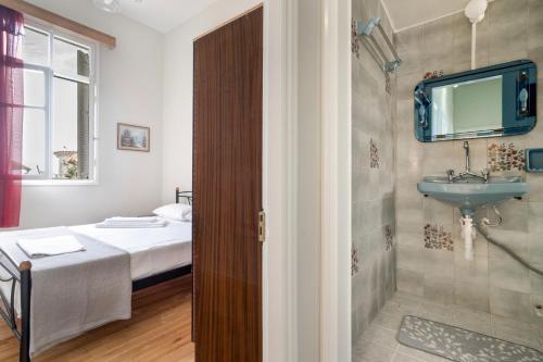 a bathroom with a bed and a sink and a mirror at El Padre Residence in Sívros