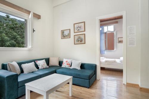 a living room with a blue couch and a table at El Padre Residence in Sívros