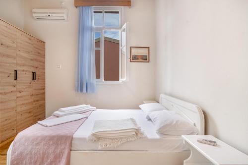a white bed in a room with a window at El Padre Residence in Sívros