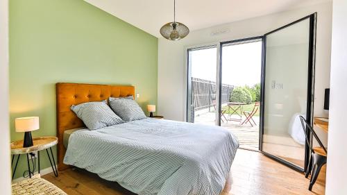a bedroom with a bed and a sliding glass door at Villa des Loups de Mer in Talmont