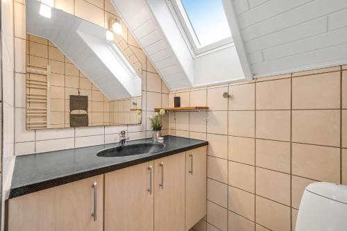 a bathroom with a sink and a skylight at Vacation Home Renovated In 2023 With A 6-Person Hot Tub - 1010 in Ringkøbing