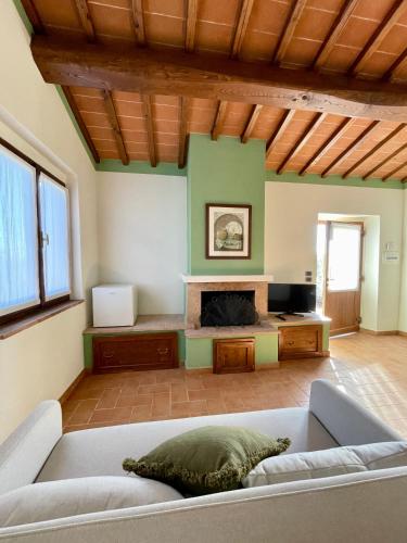 a living room with a couch and a fireplace at Casale dell'Assiolo Bed and Breakfast in Castiglione del Lago