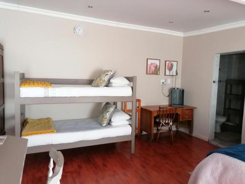 a room with three bunk beds and a desk at Hill Manor Room 2 Self catering unit in Potchefstroom