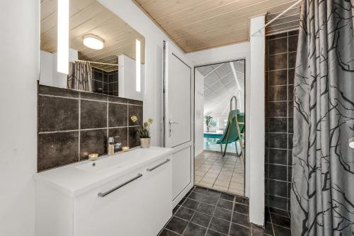un baño con lavabo y ducha en Nice Pool House For 12 Persons - 1021, en Ringkøbing