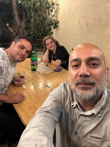 two men and a woman sitting at a wooden table at Popock City Center in Yerevan