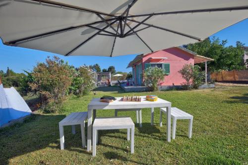 a white table and two chairs under an umbrella at Ailanto in Lygia