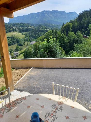 a balcony with a table and a view of a mountain at Le chant de la rivière en Chartreuse in Le Massot