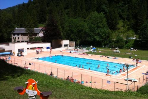 a large swimming pool with many people in it at Le chant de la rivière en Chartreuse in Le Massot