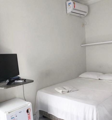a room with a bed and a television and a heater at Pousada Brisa do Mar in Aracaju