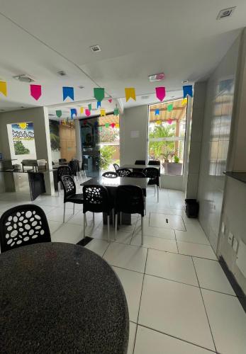 a dining room with tables and chairs and hearts on the wall at Pousada Brisa do Mar in Aracaju