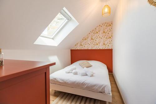 una piccola camera mansardata con letto e finestra di Evasion Paimpol appartement neuf et confortable a Paimpol
