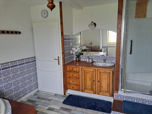 une salle de bain avec un lavabo et un miroir dans l'établissement La Maraitière, à Guînes