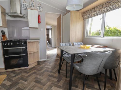 a kitchen and dining room with a table and chairs at Woodlands Lodge in Ruthin