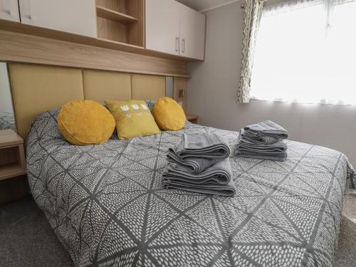 a bedroom with a bed with towels and pillows at Woodlands Lodge in Ruthin