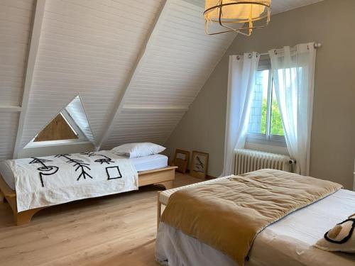 a bedroom with two beds and a window at Maison familiale - Plage 300m in Jullouville-les-Pins