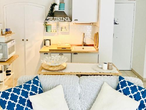 - une cuisine avec un canapé et une table avec des oreillers dans l'établissement **2P Calme Climatisé, Terrasse, Centre Menton, Proche Plages et Commerces** - FR-1-196-356, à Menton