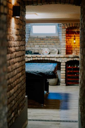 a room with a table and a brick wall at Oázis Panzió in Makó