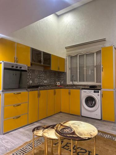 a kitchen with yellow cabinets and a washing machine at Vita appartamento in Skhirat