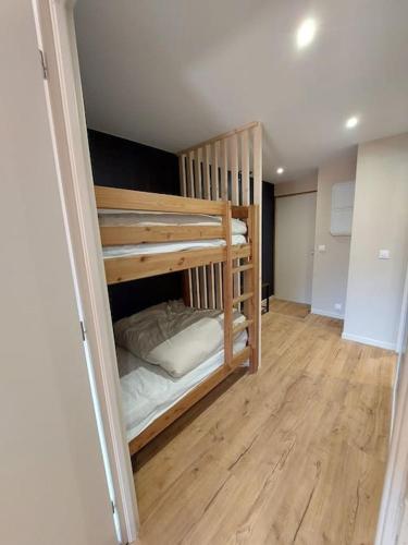 deux lits superposés dans une chambre avec parquet dans l'établissement Superbe studio à 2 pas du centre, au Bourg-dʼOisans