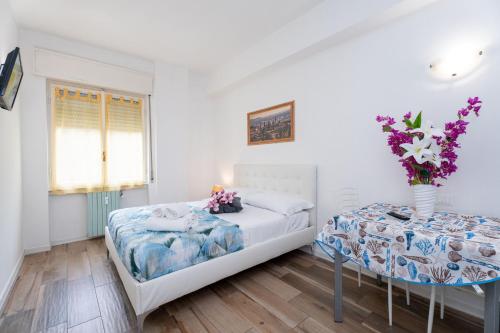 a bedroom with two beds and a vase of flowers at Station's Apartments Bergamo in Bergamo