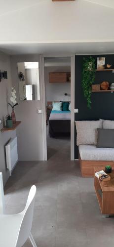 un salon avec un canapé et un lit dans l'établissement Mobil home neuf 6 personnes, à La Tremblade