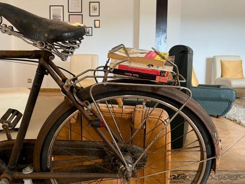 a bike with a pile of books in a living room at Vinhais Hotel in Vinhais