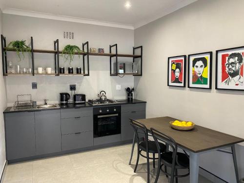 a kitchen with a table and a dining room at 46 on Allcock Guest Apartment & Luxury Room in Pretoria