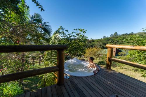 a person laying on a wooden deck at Recanto Vera Lucia in Santo Amaro da Imperatriz