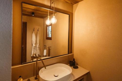 a bathroom with a white sink and a mirror at Vinha by NHôme in Ponte de Lima