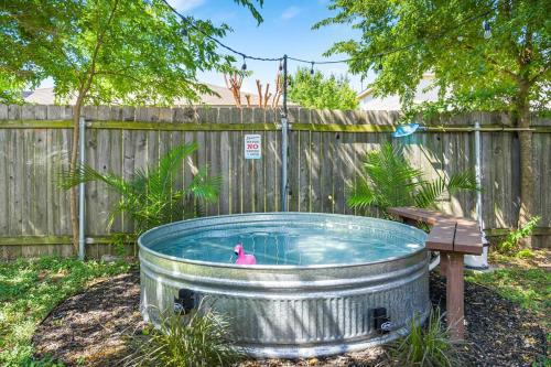 a hot tub in a yard next to a fence at Spacious Cozy Home w Gym & Pool, Kid Friendly in Pflugerville