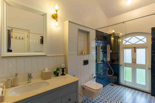 a bathroom with a sink and a toilet and a shower at LohonoStays Villa Lansdowne in Coonoor