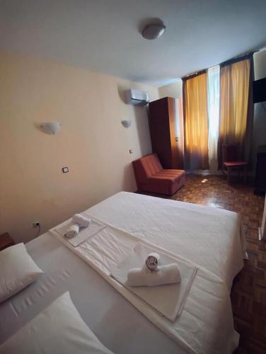 a bedroom with a large white bed with towels on it at Apartments Dunja in Sveti Stefan
