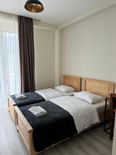 a bedroom with two beds and a large window at Aronia Kazbegi in Stepantsminda
