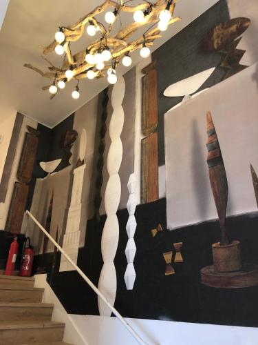 a room with a chandelier and a staircase with sculptures at MGH Massilia Green House in Marseille