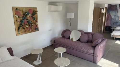 a living room with a purple couch and two tables at MGH Massilia Green House in Marseille