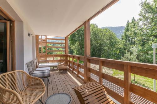 a screened in porch with chairs and tables and windows at L'Altima Megève - Eclat des Veriaz in Megève